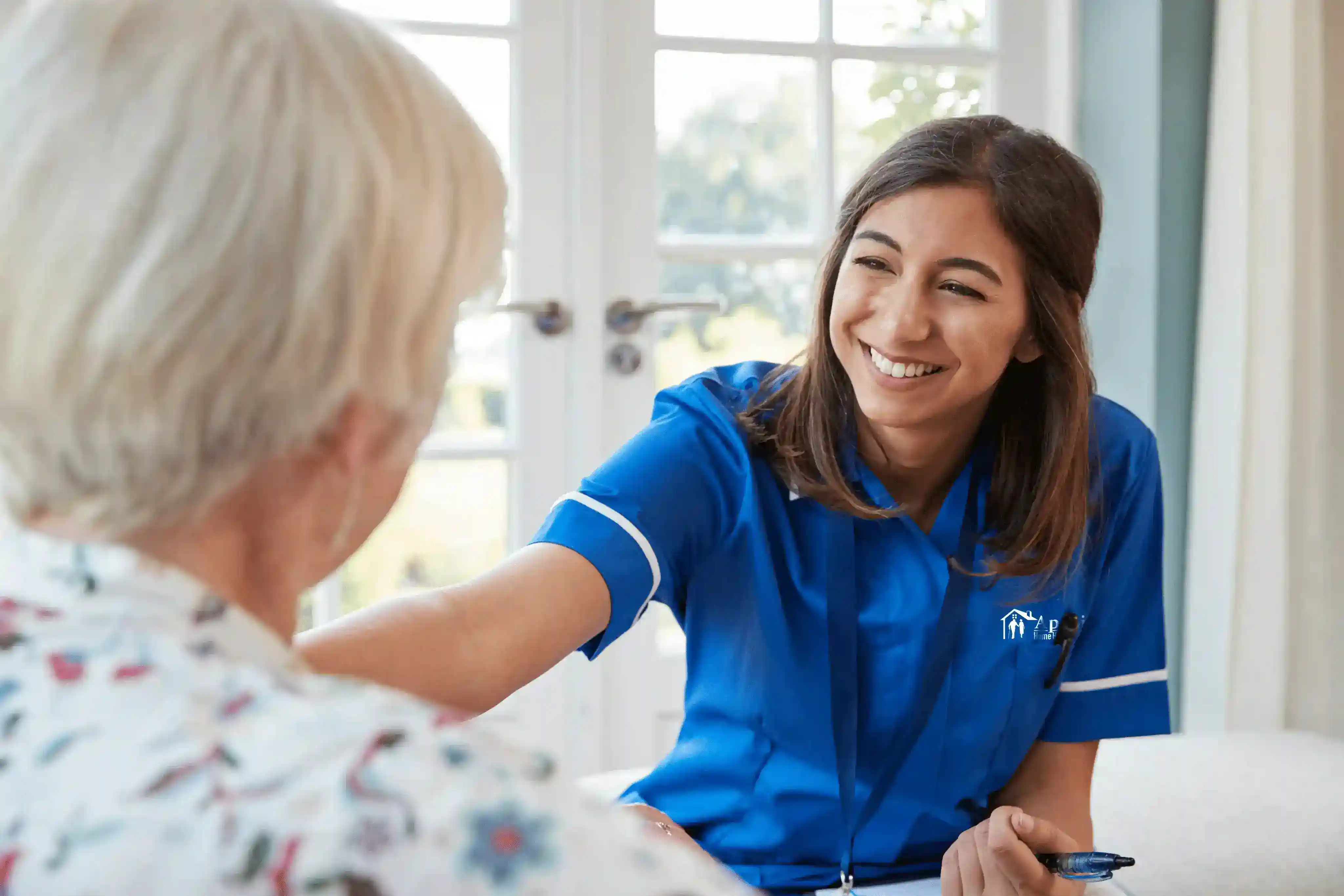 Nurse assisting an elderly woman with documents